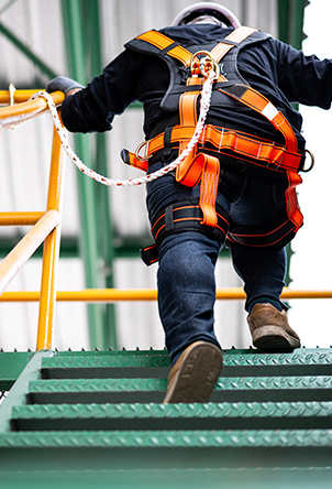 Construction-worker-walking-upstairs-with-his-safety-harness